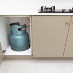 रसोई में रखा एलपीजी गैस सिलिंडर, जो घरेलू उपयोग को दर्शाता है