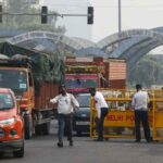 नोएडा श्रमिक प्रदर्शन के दौरान सड़क पर भीड़, जलती गाड़ियां और पुलिस तैनाती का दृश्य