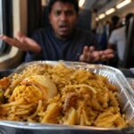 यह चित्र ट्रेन के अंदर परोसे गए खाने को दिखाता है, जिसमें एग बिरयानी में कीड़ा नजर आ रहा है, जो फूड क्वालिटी की समस्या को दर्शाता है।