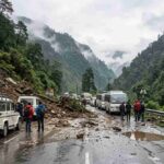 एक पहाड़ी सड़क पर बर्फबारी और भूस्खलन के कारण टूटी सड़क और फंसे हुए वाहन दिखते हुए