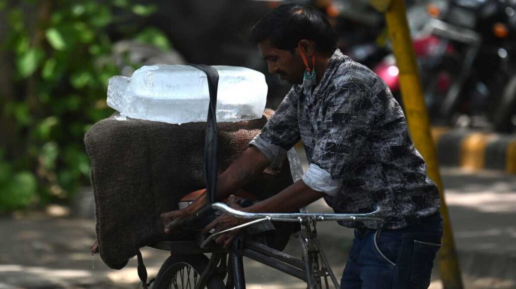 तेज धूप और गर्म हवाओं के बीच सड़क पर चलते लोग, जो हीटवेव की स्थिति को दर्शाता है